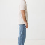 Homme de profil en polo beige et jean