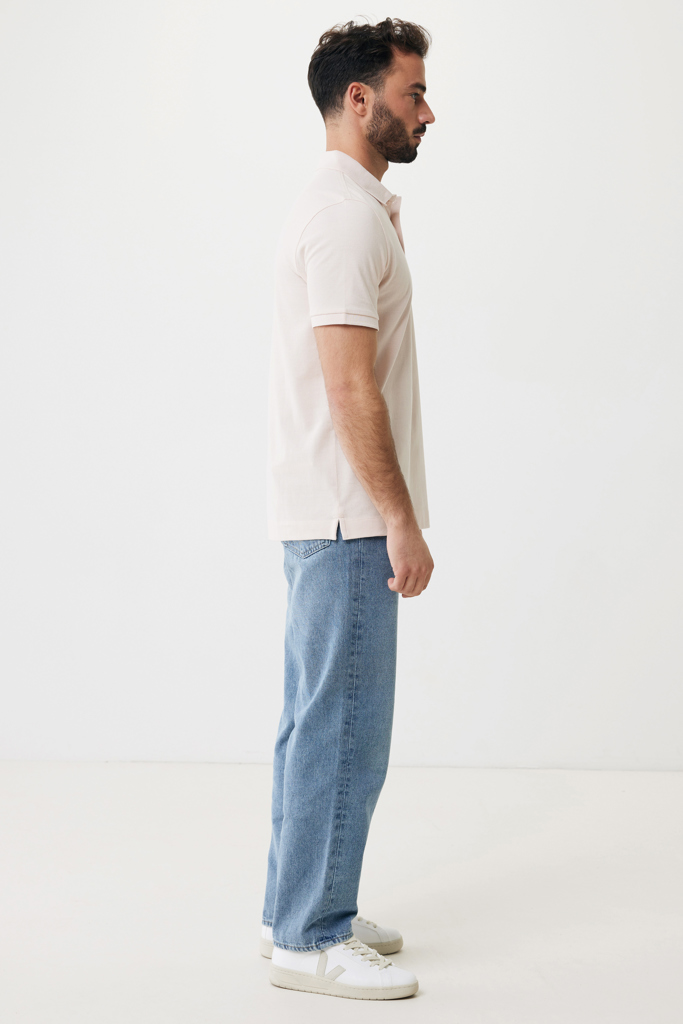 Homme de profil en polo beige et jean