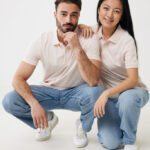 Couple souriant en polos beiges sur fond blanc