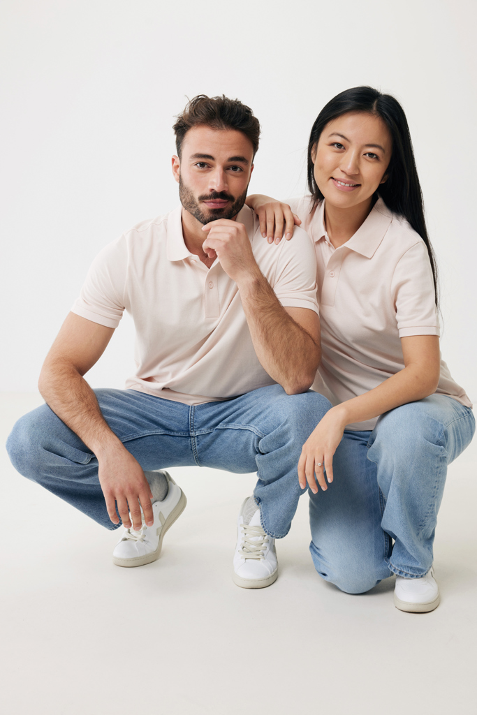 Couple souriant en polos beiges sur fond blanc