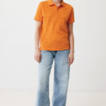 Femme souriante en polo orange et jean large