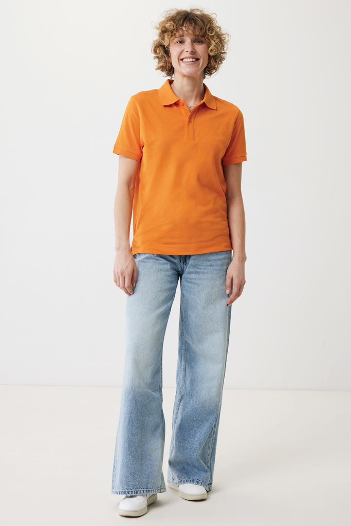 Femme souriante en polo orange et jean large