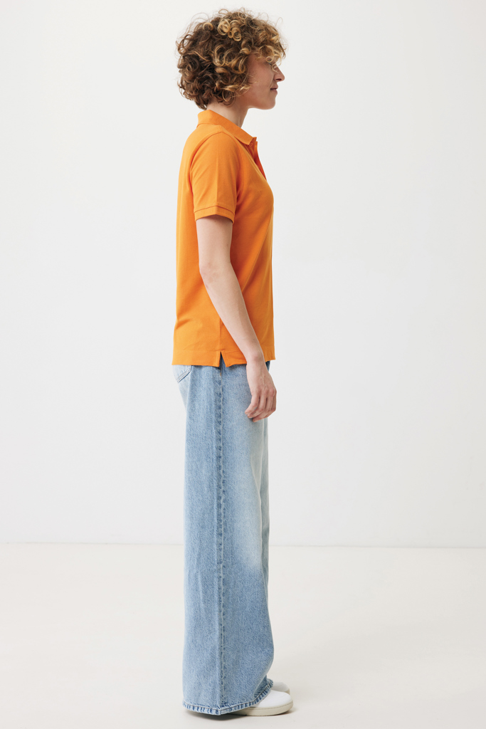 Profil d’une femme en polo orange et jean large