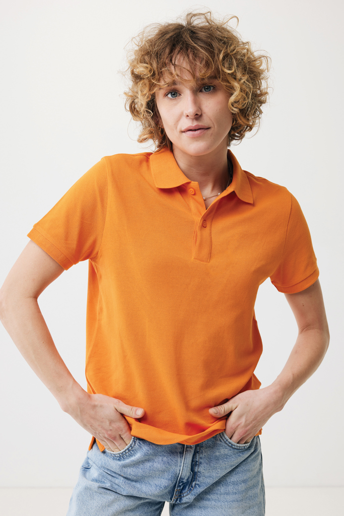 Personne en polo orange sur fond neutre