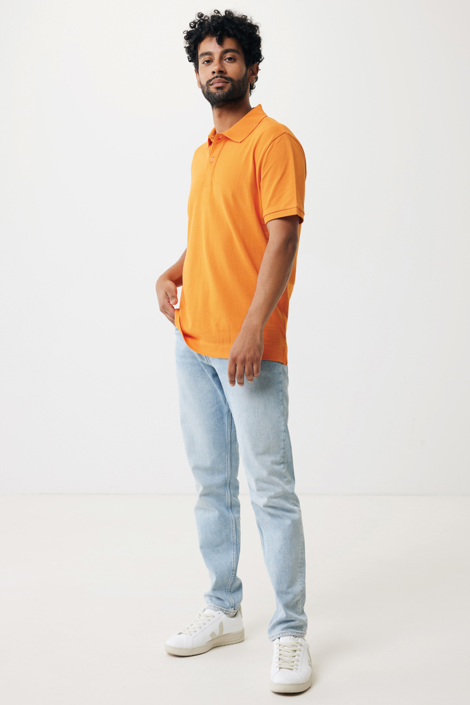 Homme en polo orange et jean clair