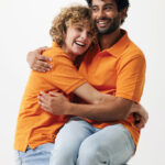 Couple souriant enlacé sur fond neutre