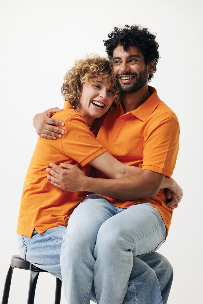 Couple souriant enlacé sur fond neutre