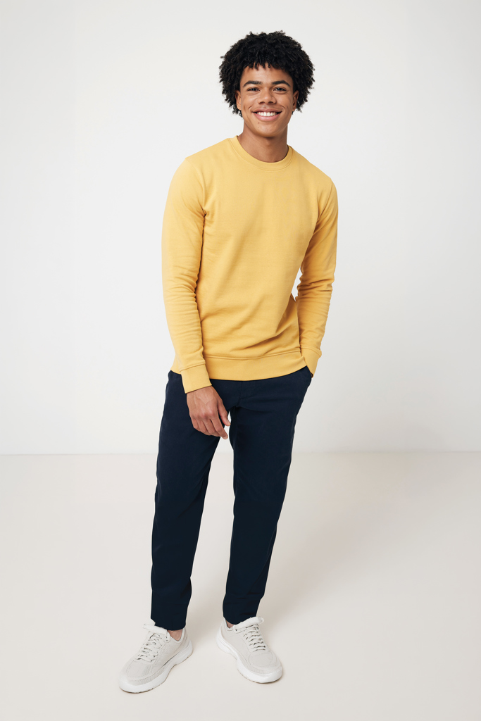 Jeune homme souriant en sweat jaune et baskets blanches