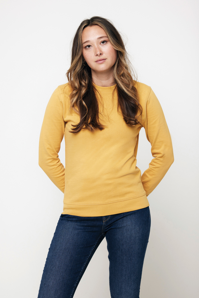 Femme en sweat jaune et jean bleu