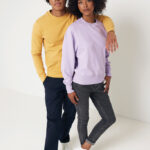Deux jeunes adultes en sweats colorés posant
