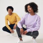 Deux modèles en sweats pastel accroupis en studio