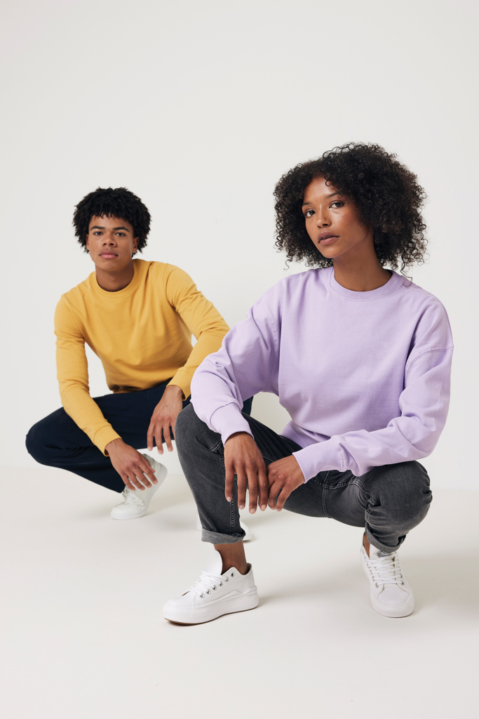 Deux modèles en sweats pastel accroupis en studio