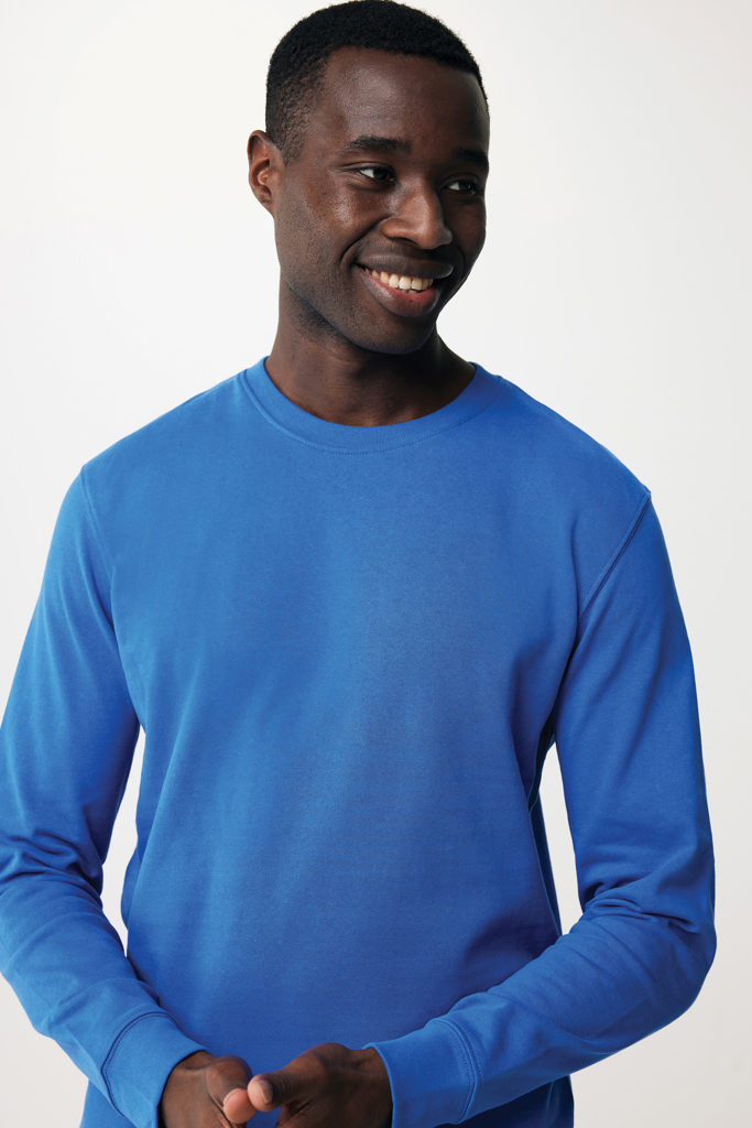Homme souriant en sweat bleu sur fond neutre