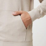 Main dans la poche d’un sweat beige