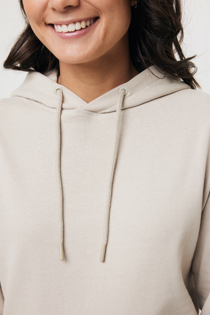 Femme souriante portant un sweat à capuche beige