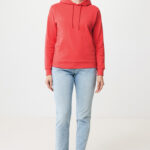 Femme souriante en hoodie rouge et jean