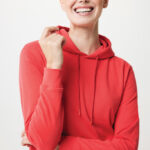 Femme souriante en sweat à capuche rouge