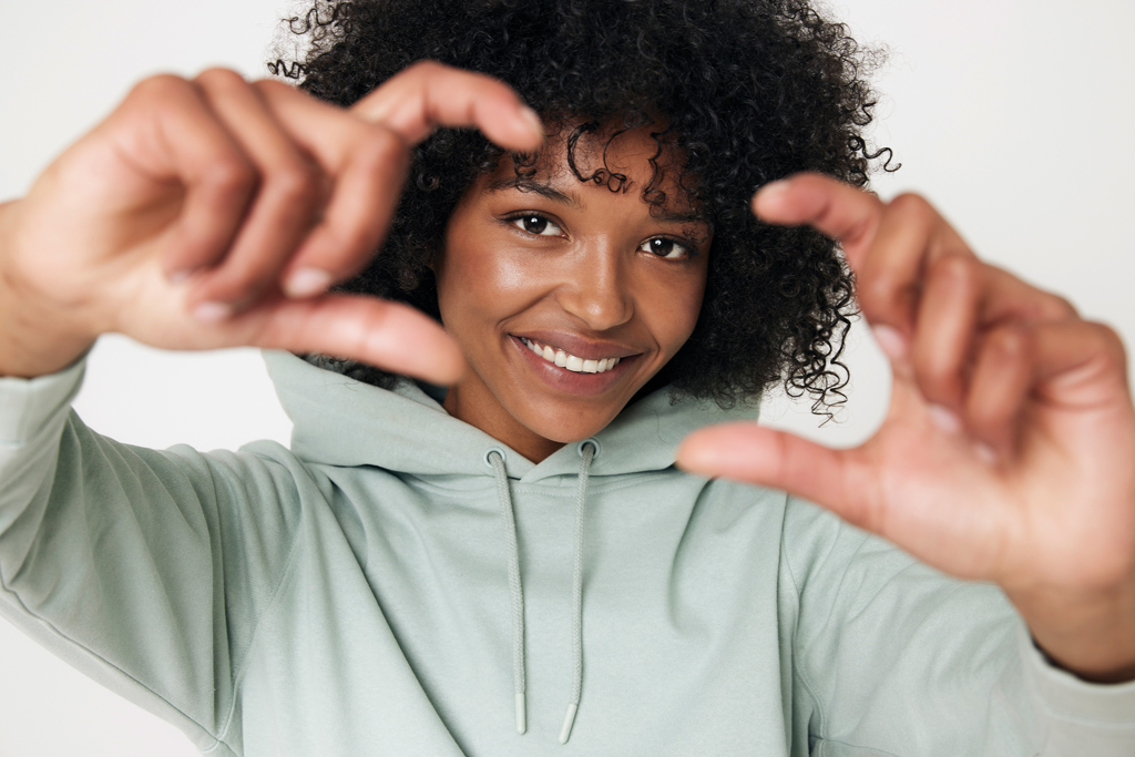Femme souriante cadrant avec ses doigts