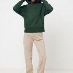 Femme portant sweat vert et pantalon beige