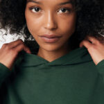 Portrait femme aux cheveux bouclés en sweat vert
