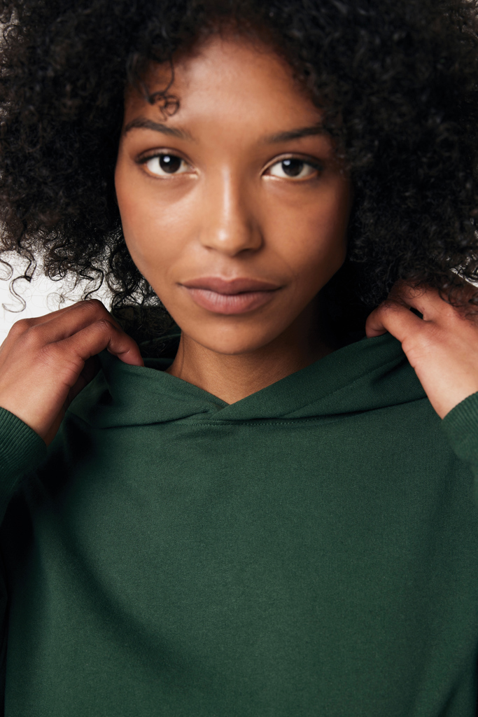 Portrait femme aux cheveux bouclés en sweat vert