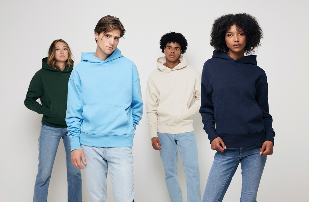 Quatre jeunes portant des sweats à capuche colorés