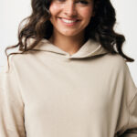 Femme souriante portant un sweat à capuche beige