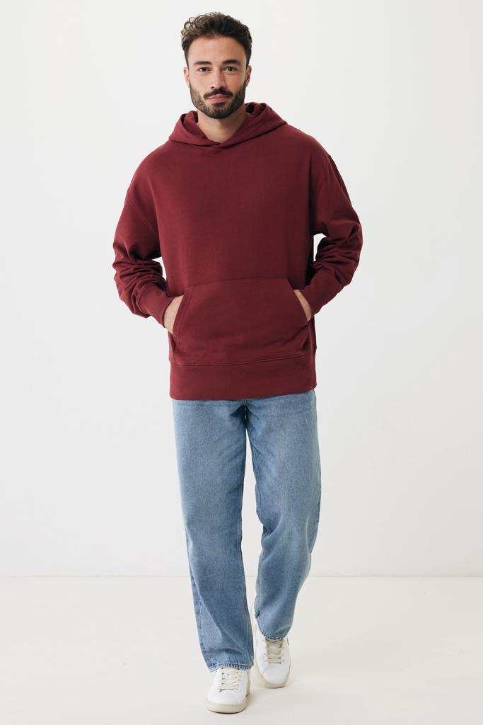 Homme portant sweat à capuche bordeaux et jean clair