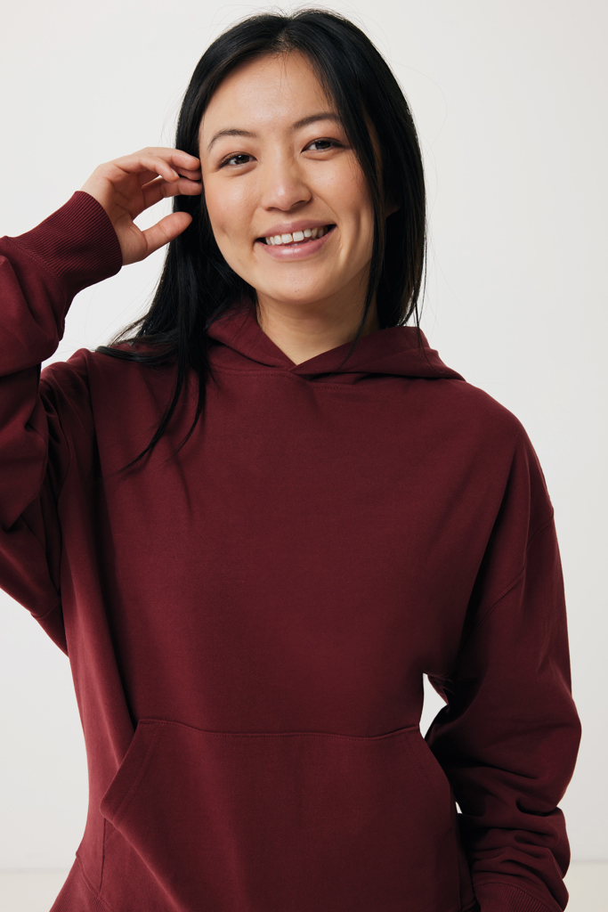 Jeune femme souriante en sweat bordeaux