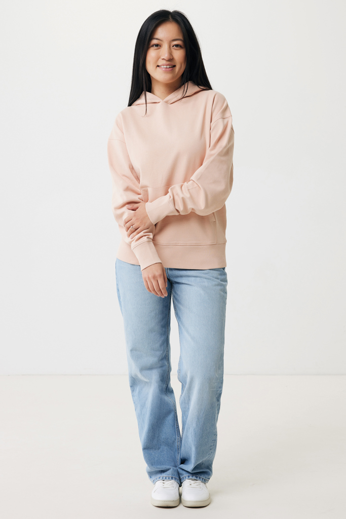 Femme souriante en hoodie rose et jean clair
